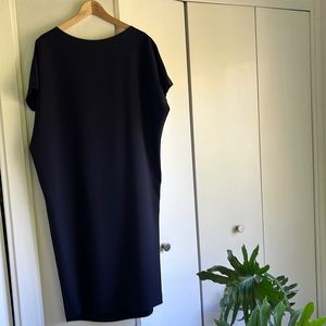 Mid length with a natural loose drape and cut out in the back. 100% Polyester.